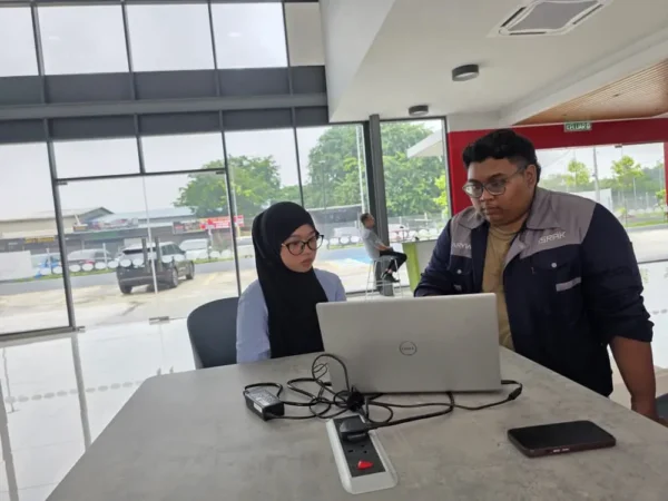 Israk Solutions trainer demonstrating the CDMS content management system on the floor standing kiosk at Perodua Jalan Reko