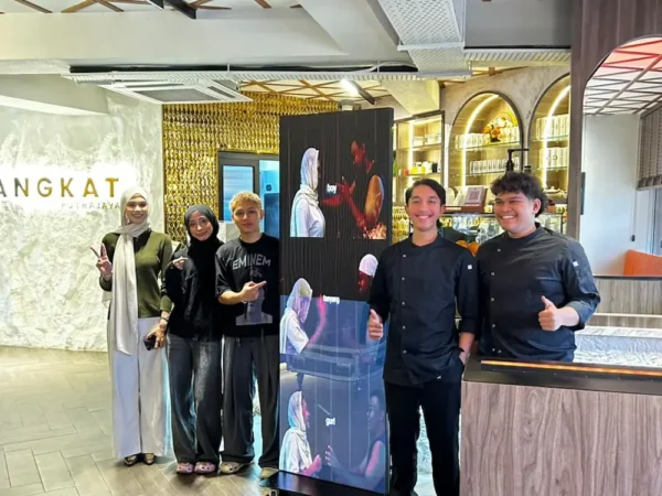 Changkat Cafe team beside the LED poster for cafe playing video content, deployed by Israk Solutions