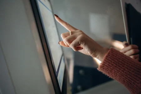 Touchscreen Kiosk Technology: Enhancing User Experience In The Digital Age touch screen modern technology woman is using banking terminal indoors
